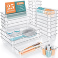 Clear plastic drawer organizer trays in several sizes arranged in a drawer